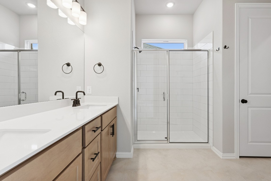 247 Grayson Elm Pass Dripping Springs, TX 78620 - Photo 13 of 39 a bathroom with a sink a mirror and a shower