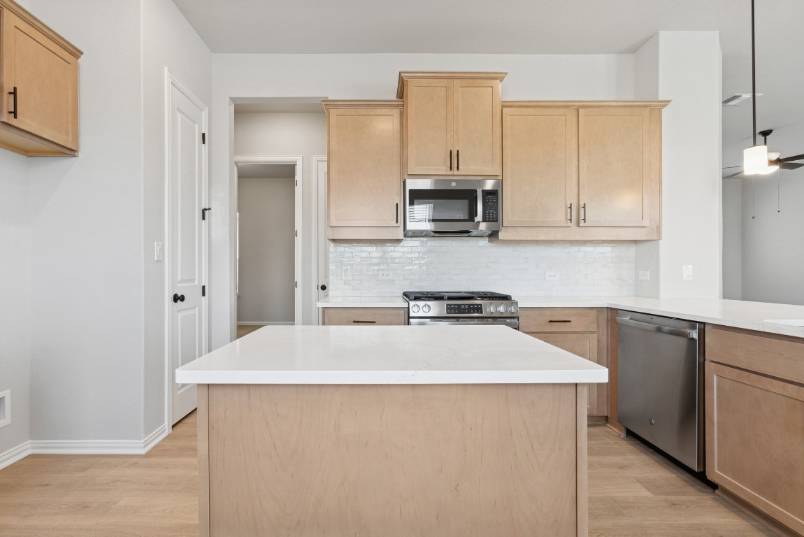 247 Grayson Elm Pass Dripping Springs, TX 78620 - Photo 16 of 39 a kitchen with stainless steel appliances a stove refrigerator sink and cabinets
