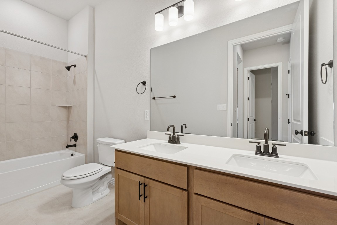 247 Grayson Elm Pass Dripping Springs, TX 78620 - Photo 25 of 39 a bathroom with a sink a toilet and shower