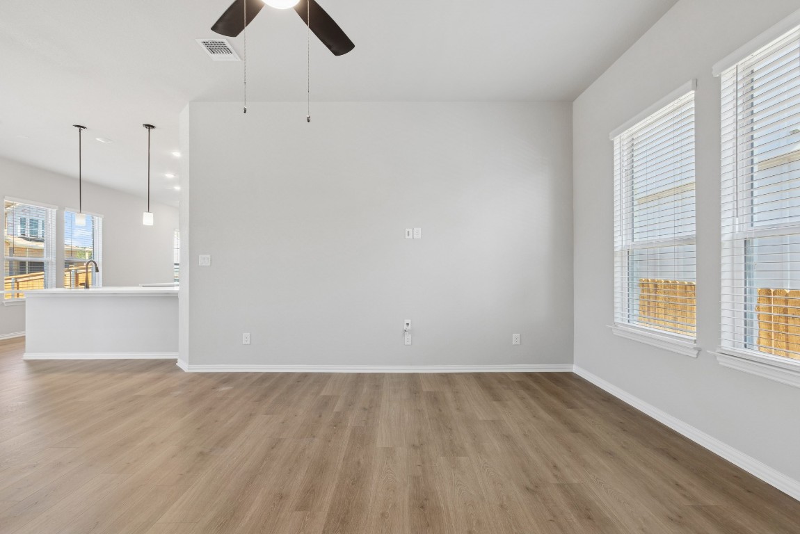 247 Grayson Elm Pass Dripping Springs, TX 78620 - Photo 9 of 39 an empty room with wooden floor and windows