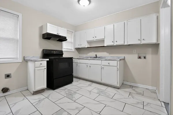 a kitchen with white cabinets and appliances