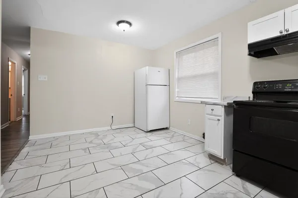 a kitchen with white cabinets and appliances