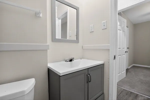 a bathroom with a sink a toilet and a mirror
