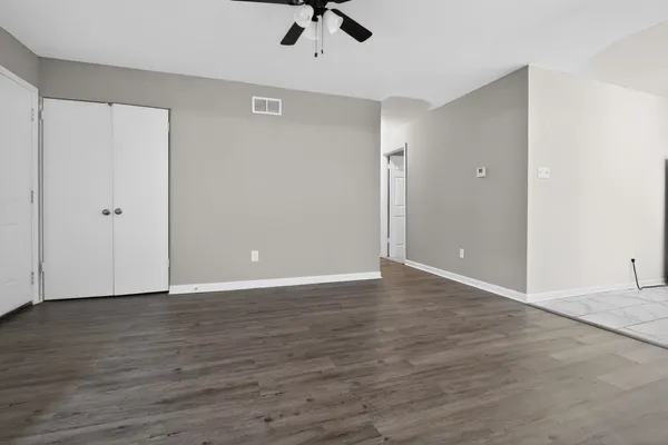 a view of an empty room with wooden floor