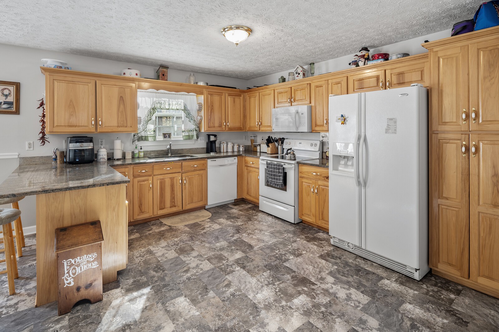 8035 Cedar Grove Road Cross Plains, TN 37049 - Photo 31 of 40 a kitchen with stainless steel appliances granite countertop a refrigerator a stove top oven a sink and dishwasher
