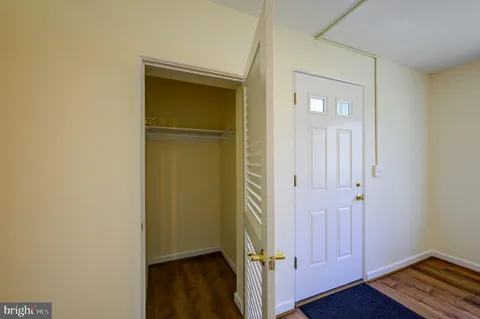 an empty room with wooden floor and closet area