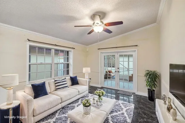 a bedroom with a large bed and a chandelier fan