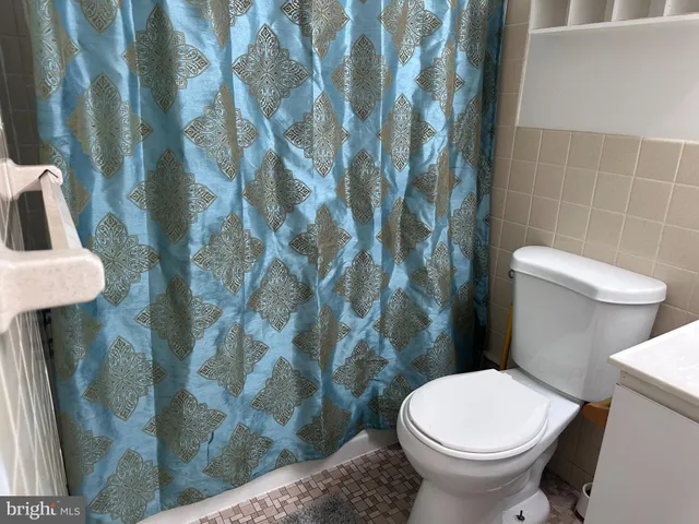 a white toilet sitting next to a shower curtain