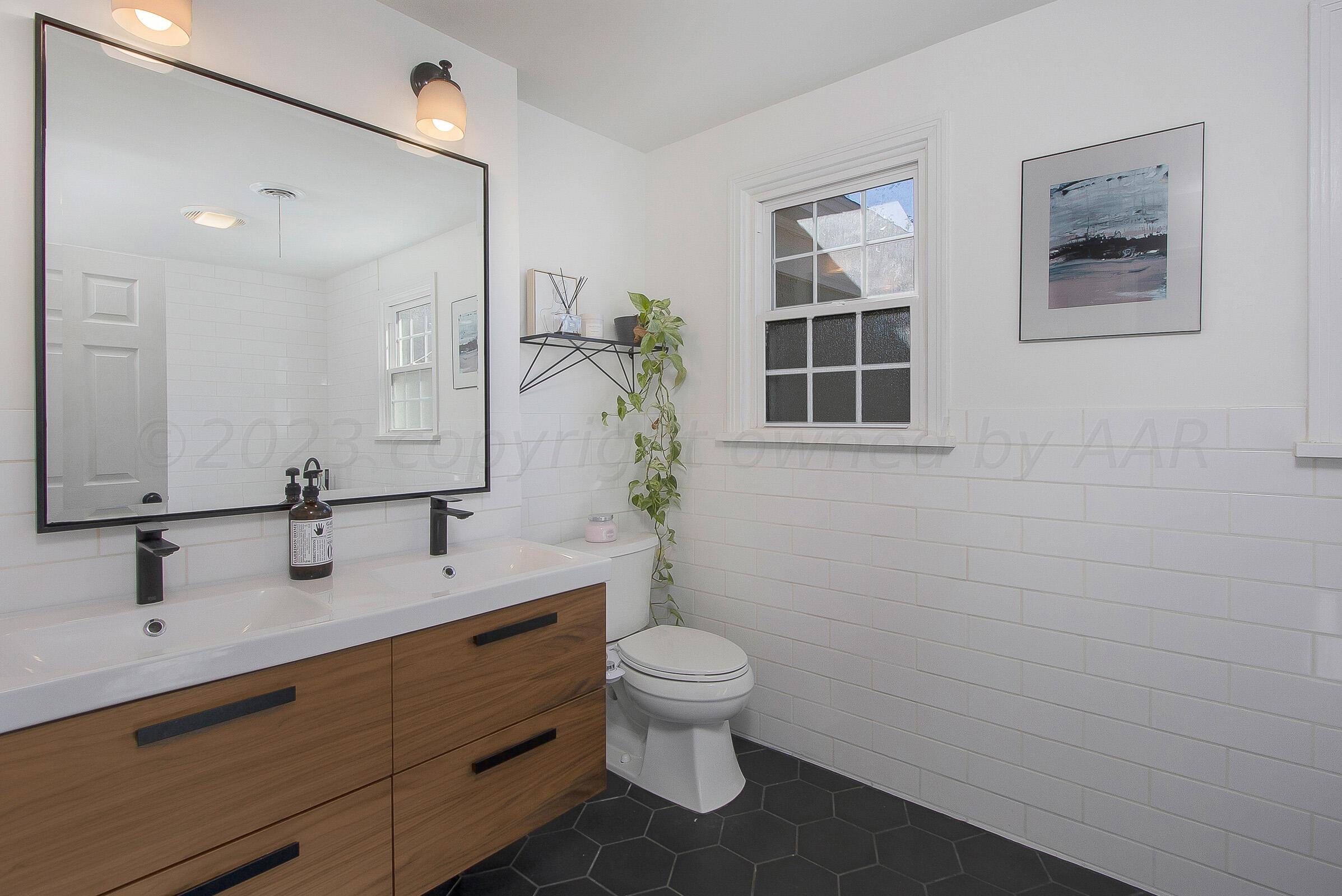2102 South Hayden Street Amarillo, TX 79109 - Photo 23 of 33 a bathroom with a double vanity sink toilet and a mirror