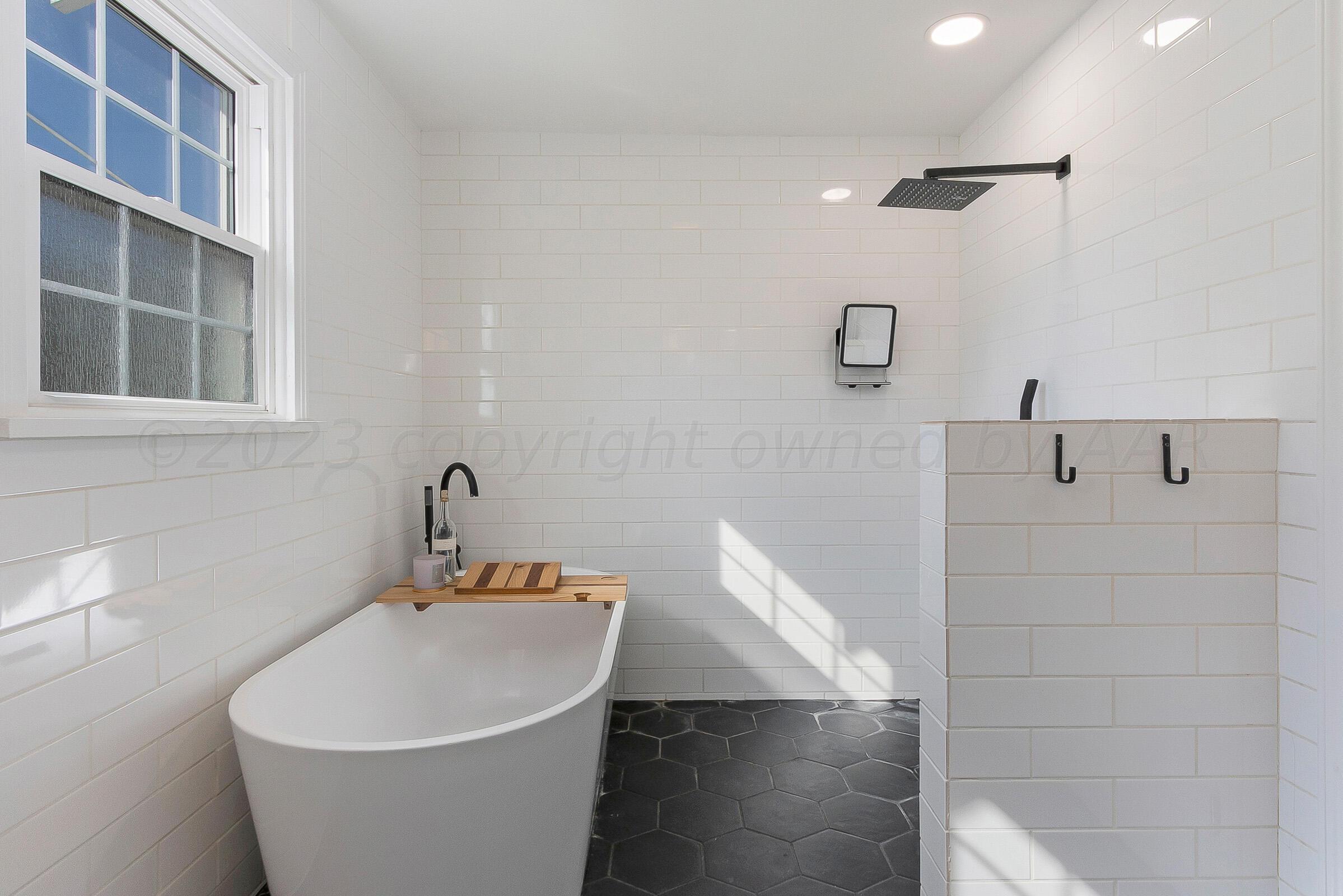 2102 South Hayden Street Amarillo, TX 79109 - Photo 24 of 33 a white bath tub sitting in a bathroom