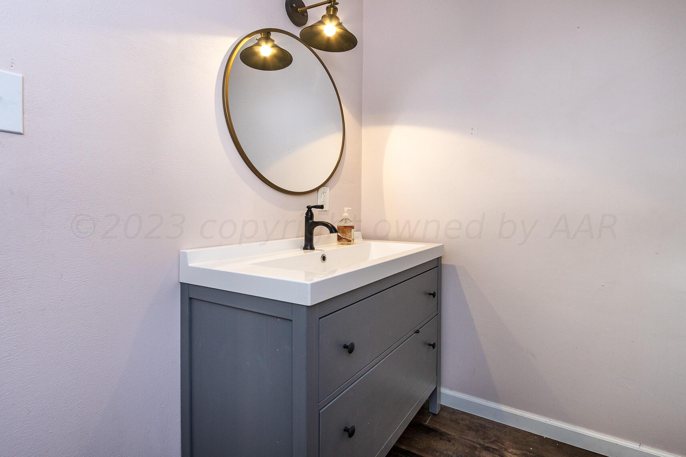 2102 South Hayden Street Amarillo, TX 79109 - Photo 27 of 33 a bathroom with a sink and a mirror