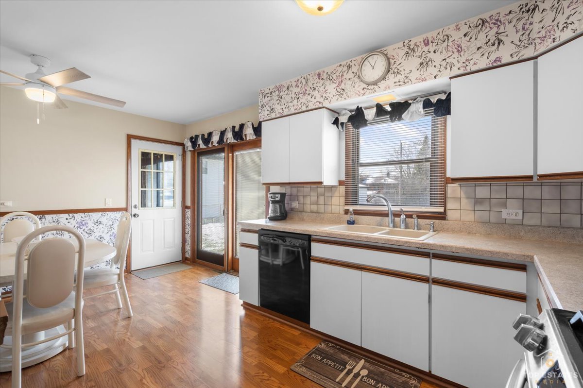 216 Evergreen Street Addison, IL 60101 - Photo 12 of 43 a kitchen with stainless steel appliances a sink a stove a refrigerator cabinets and a dining table with wooden floor