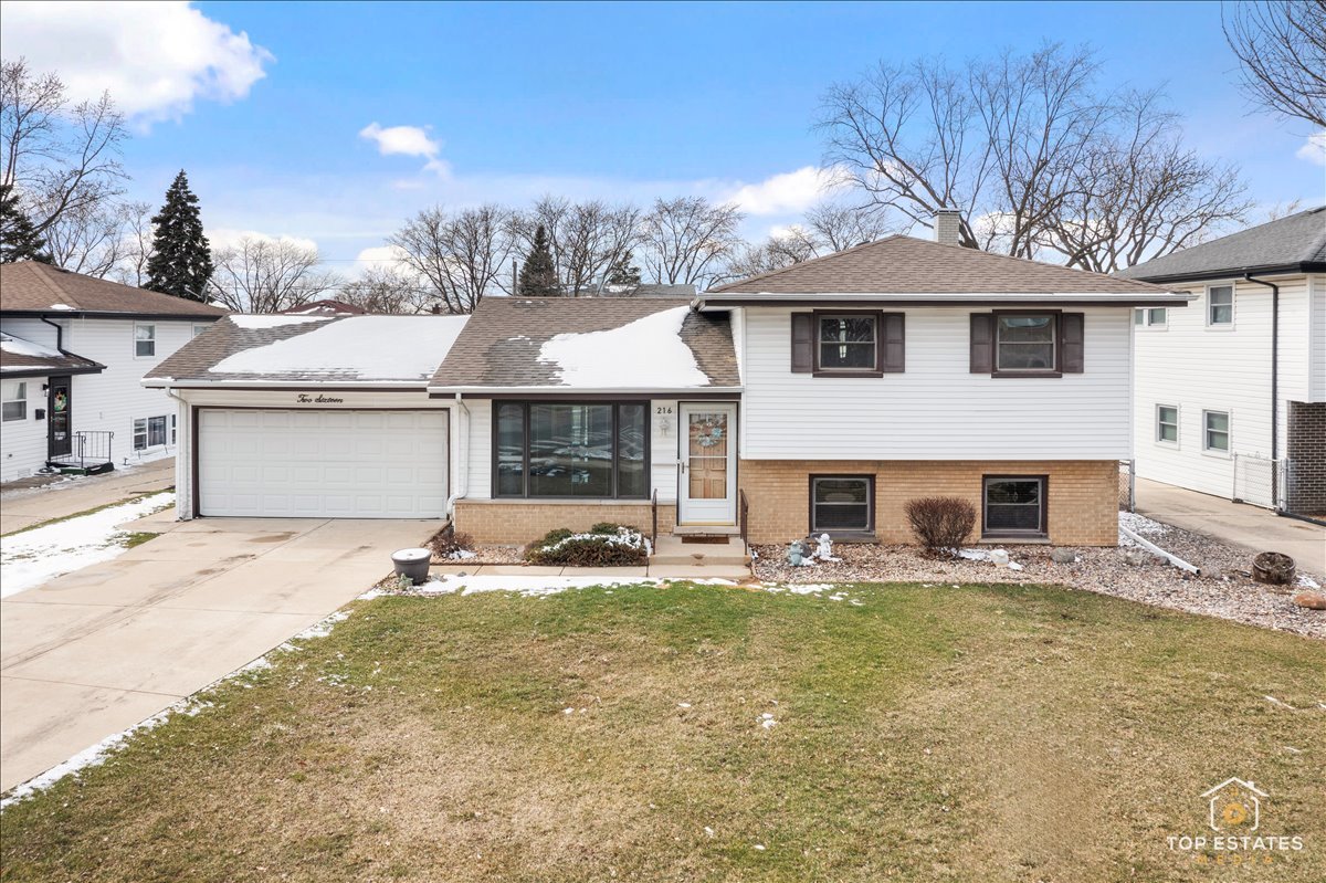216 Evergreen Street Addison, IL 60101 - Photo 2 of 43 a front view of a house with a yard and garage