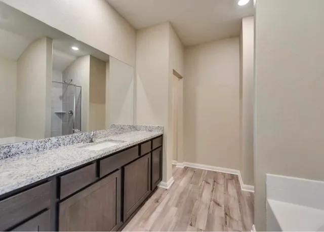 a bathroom with a granite countertop sink and a mirror