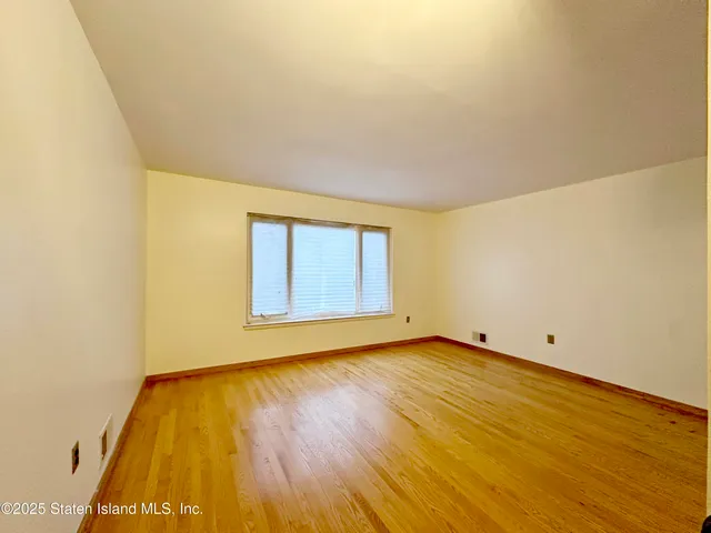 a view of a room with wooden floor and a ceiling fan