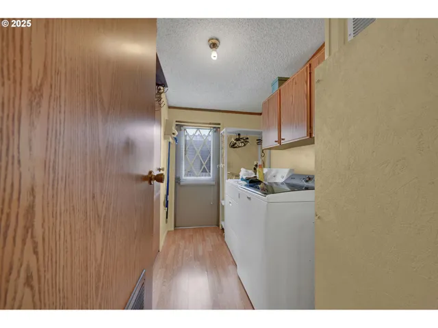a kitchen with a refrigerator and a wooden floor