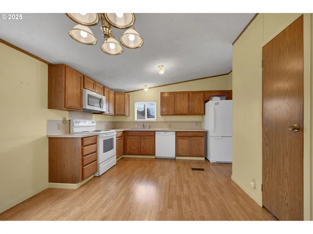 a kitchen with stainless steel appliances granite countertop a sink cabinets and wooden floor