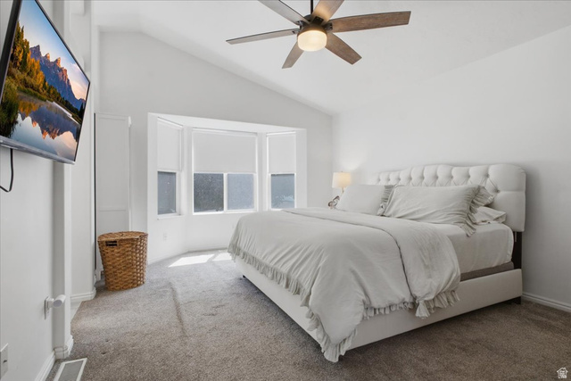 12151 Andrew View Circle Draper, UT 84020 - Photo 16 of 31 Spacious bedroom featuring a vaulted ceiling with a ceiling fan, a bay window with window coverings, soft gray carpeting, and a built-in cabinet