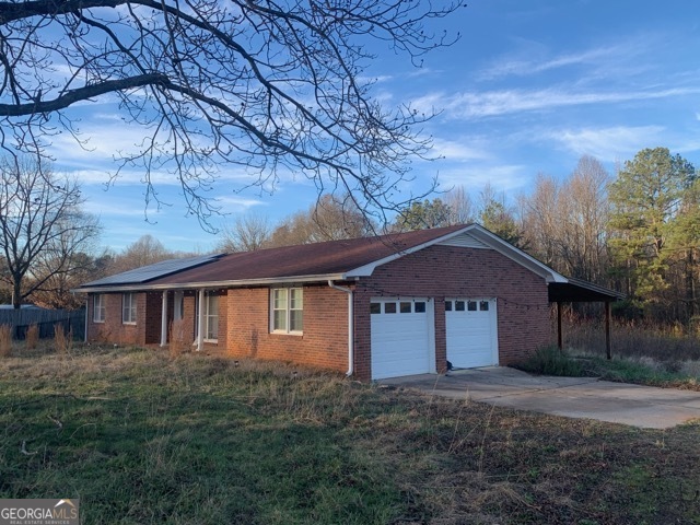 8750 Sandy Cross Road Carnesville, GA 30521 - Photo 3 of 6 a front view of a house with a yard and garage
