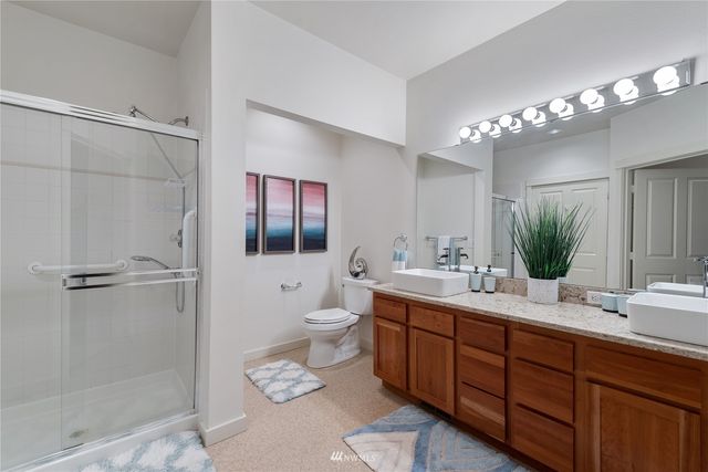a bathroom with a double vanity sink mirror and toilet
