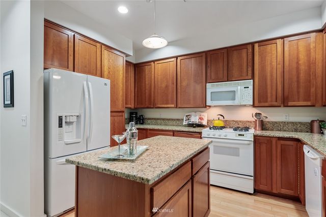 a kitchen with stainless steel appliances granite countertop a refrigerator sink and cabinets