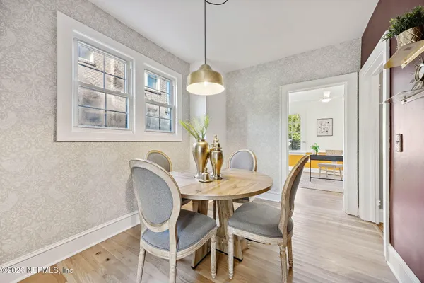 a dining room with furniture a window and wooden floor