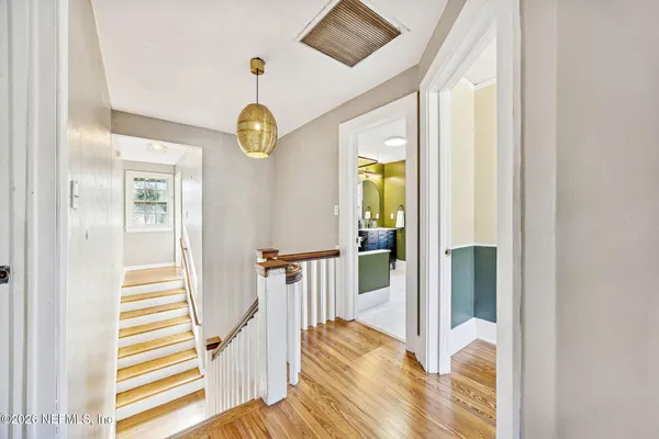 a view of a hallway with wooden floor and windows