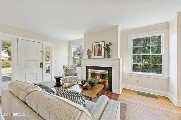 a living room with furniture a fireplace and a window