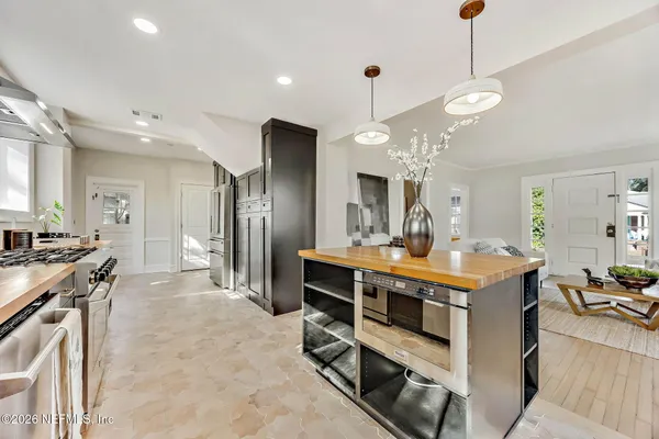 a large kitchen with stainless steel appliances a stove a sink and a refrigerator