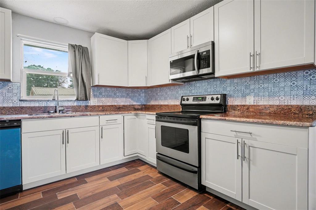355 South Oak Avenue Frostproof, FL 33843 - Photo 11 of 35 a kitchen with granite countertop white cabinets and white appliances