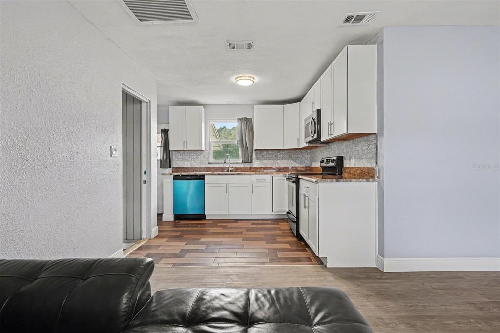 355 South Oak Avenue Frostproof, FL 33843 - Photo 13 of 35 a living room with stainless steel appliances kitchen island granite countertop furniture and a view of kitchen