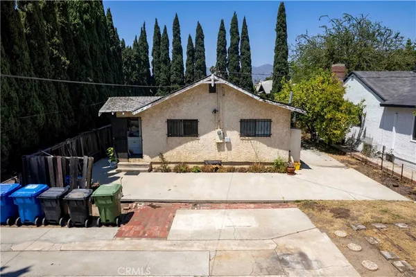 a view of a house with backyard and trees