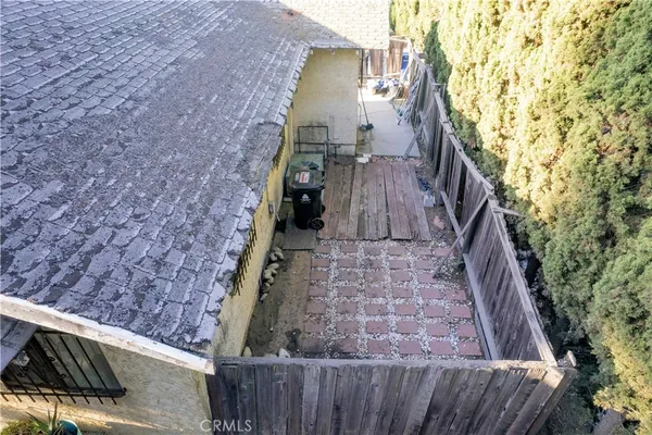 a view of a backyard with wooden floor and fence
