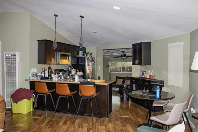 a kitchen with stainless steel appliances granite countertop a stove a refrigerator a kitchen island a dining table and chairs