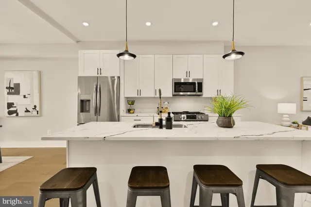 a kitchen with a table chairs refrigerator and microwave