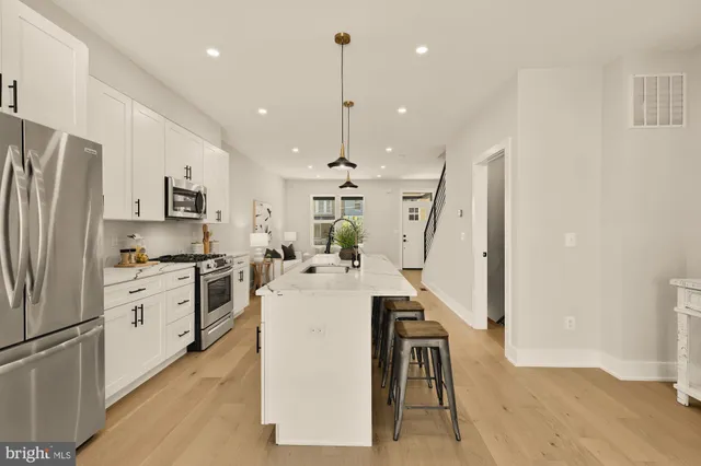 a kitchen with white cabinets and stainless steel appliances
