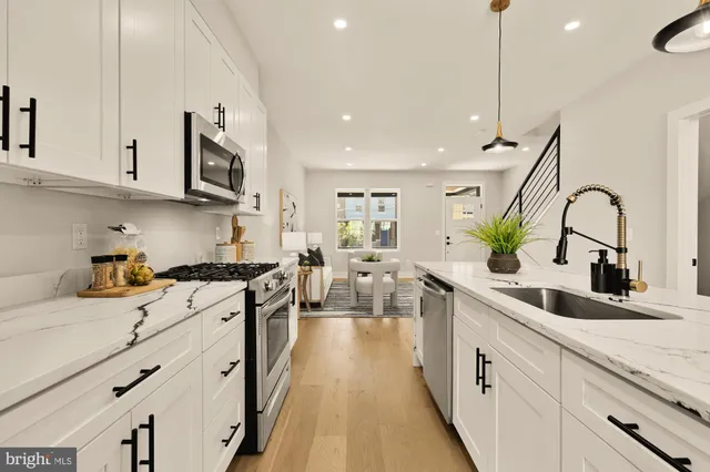 a kitchen with stainless steel appliances a sink stove and cabinets