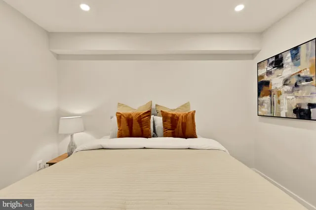 a large bed sitting in a bedroom and a lamp