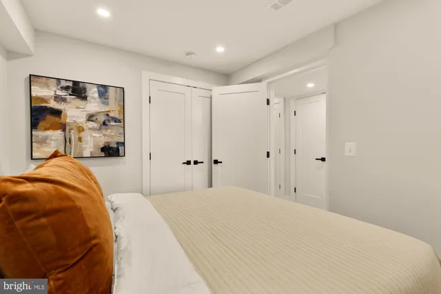 a bedroom with a bed and a painting on the wall