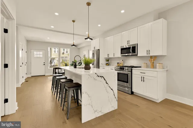 a kitchen with white cabinets and stainless steel appliances