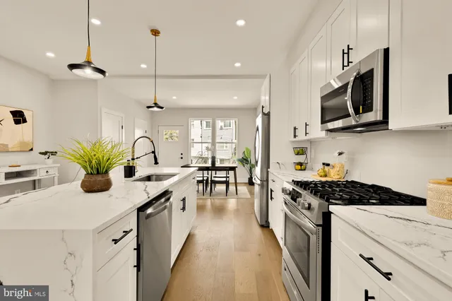 a kitchen with stainless steel appliances kitchen island granite countertop a stove a sink and a microwave