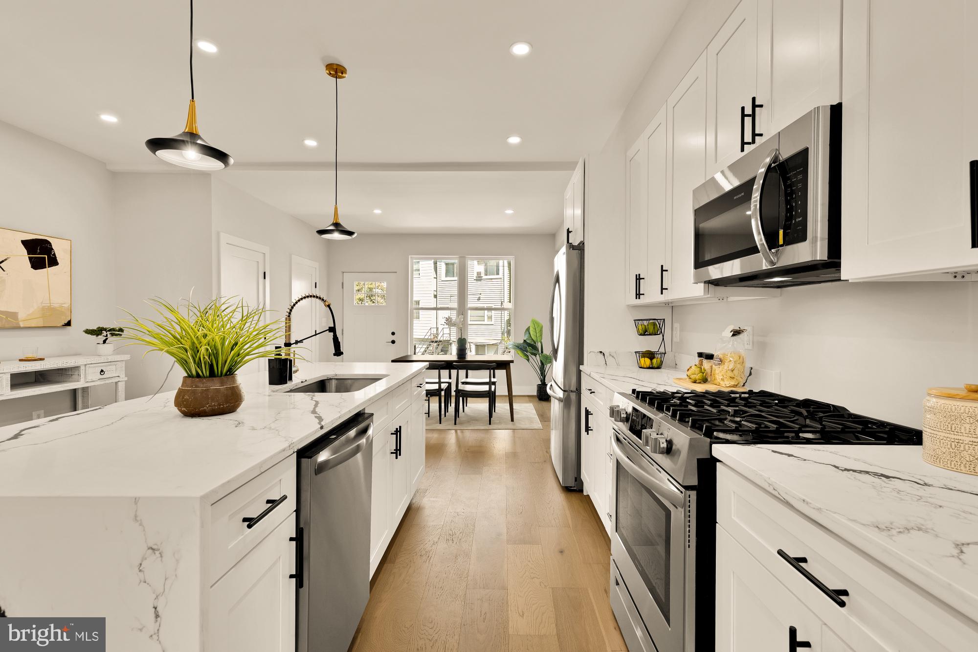 815 Marietta Place Northwest Washington, DC 20011 - Photo 8 of 44 a kitchen with stainless steel appliances kitchen island granite countertop a stove a sink and a microwave