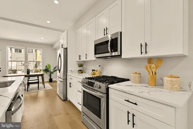 a kitchen with stainless steel appliances granite countertop a stove a sink and a microwave