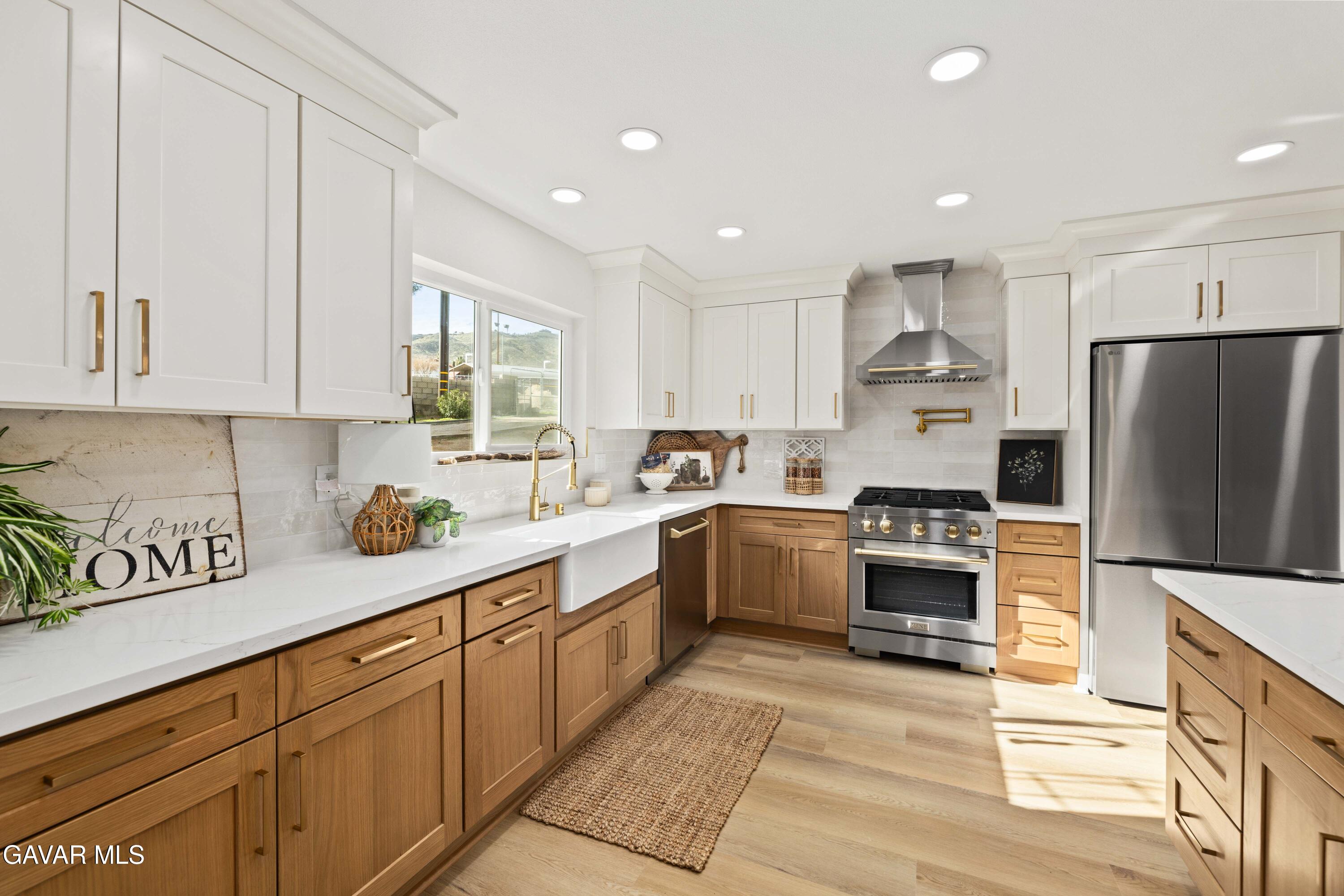 329 East Lago Lindo Road Palmdale, CA 93550 - Photo 2 of 39 a kitchen with kitchen island granite countertop a sink a stove a refrigerator cabinets and a counter top space