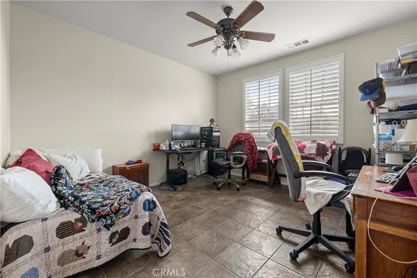 a bedroom with a bed a chair and a chandelier