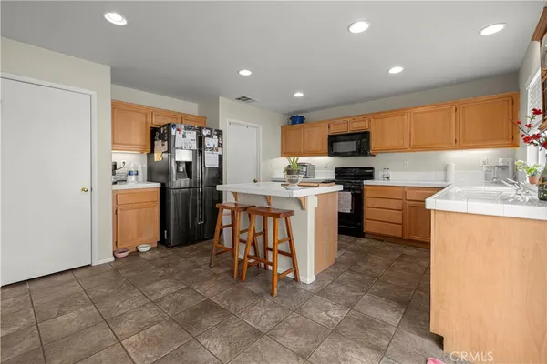 a kitchen with a sink a counter top space stainless steel appliances and cabinets