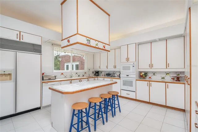 a kitchen with appliances a sink a counter top space and cabinets