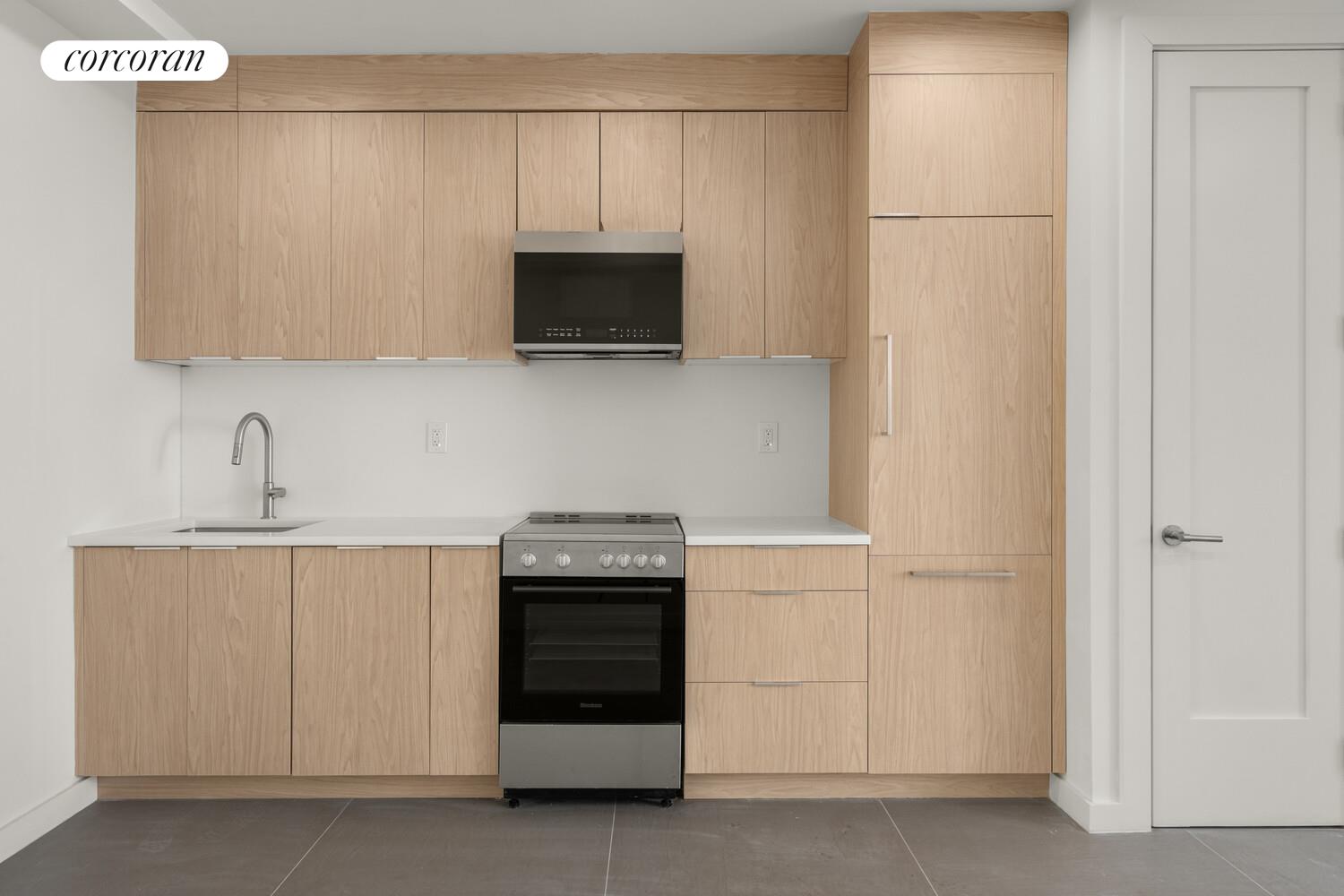 1148 Decatur Street Brooklyn, NY 11207 - Photo 13 of 14 a kitchen with white cabinets and stainless steel appliances