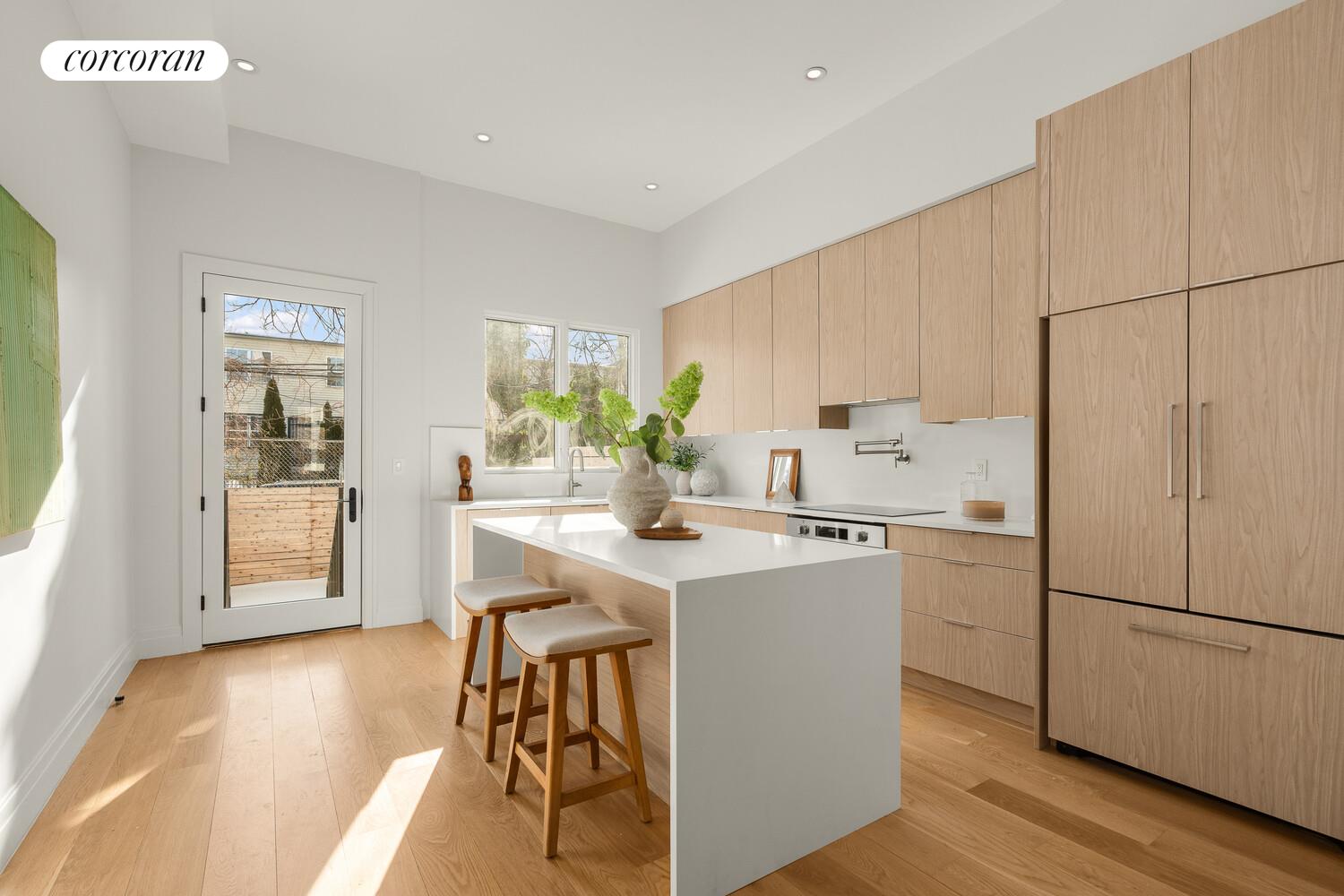 1148 Decatur Street Brooklyn, NY 11207 - Photo 3 of 14 a kitchen with a sink a center island cabinets and stainless steel appliances