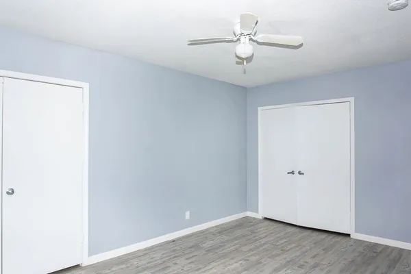 an empty room with a window and ceiling fan